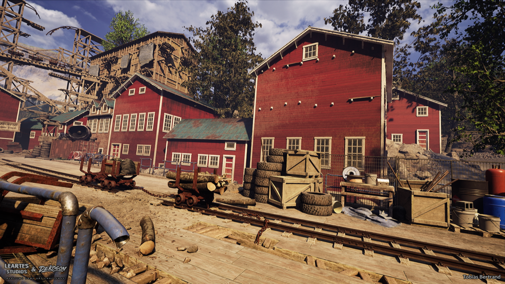 Storage yard between red mining buildings with stacked tires, wooden crates, and barrels beside an ore cart on rails